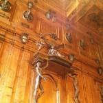 Ornate wooden paneling and statues in historic interior, showcasing intricate craftsmanship and classical design.