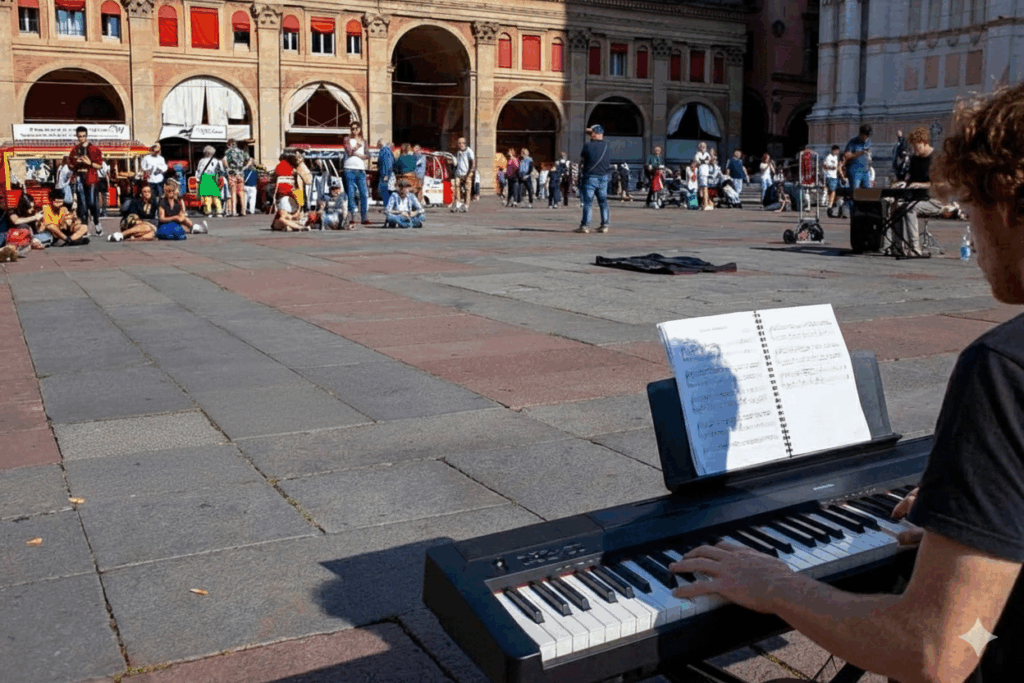 Wide view of Piazza Maggiore, Bologna, with a musician busking near San Petronio as people gather around.