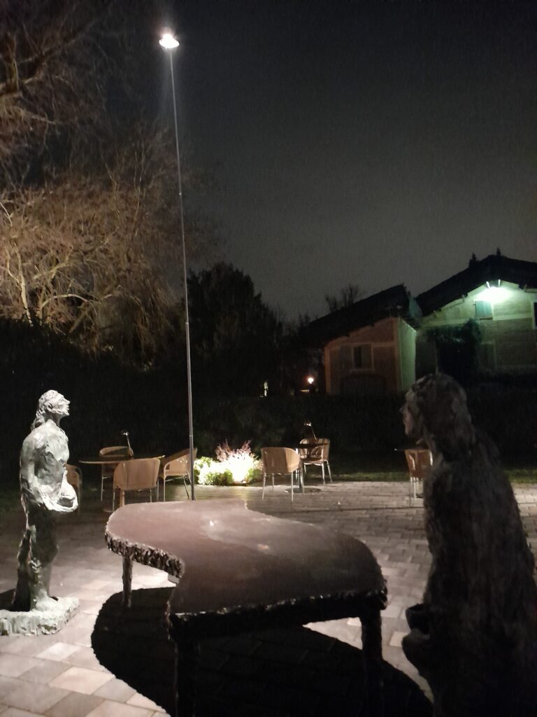 Casa Maria Luigia exterior at night with illuminated facade and sculpture, Modena