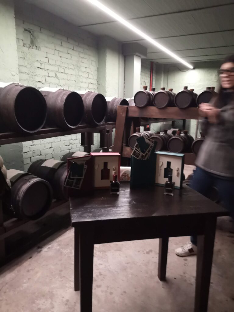 A visitor tasting traditional balsamic vinegar inside an acetaia in Modena