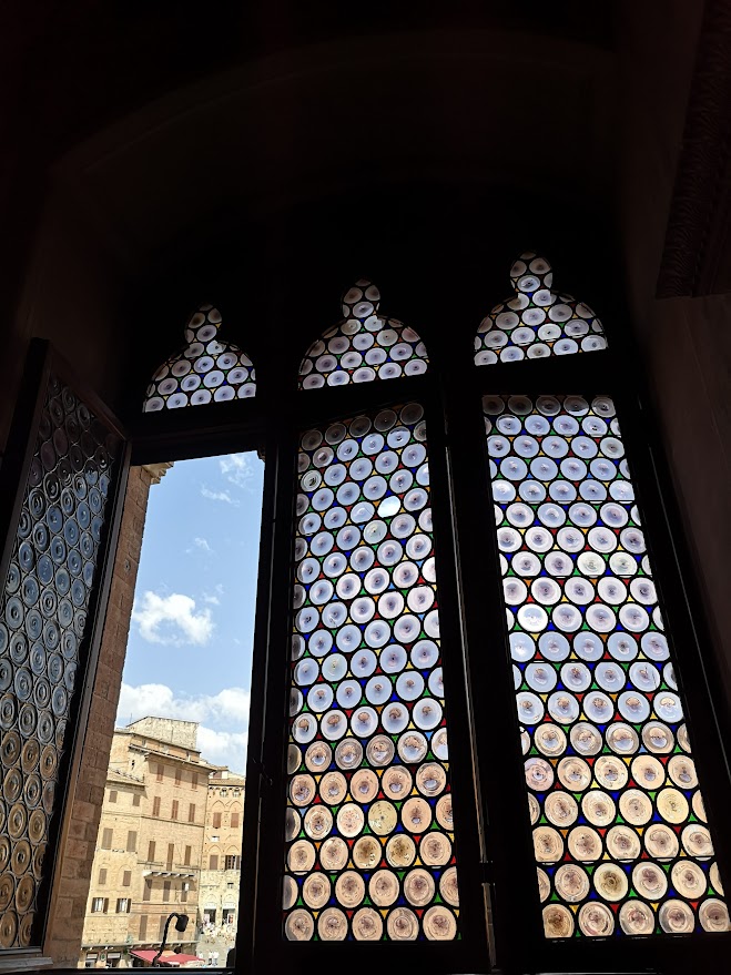 Ornate bull's-eye glass window inside a historic castle in Emilia-Romagna