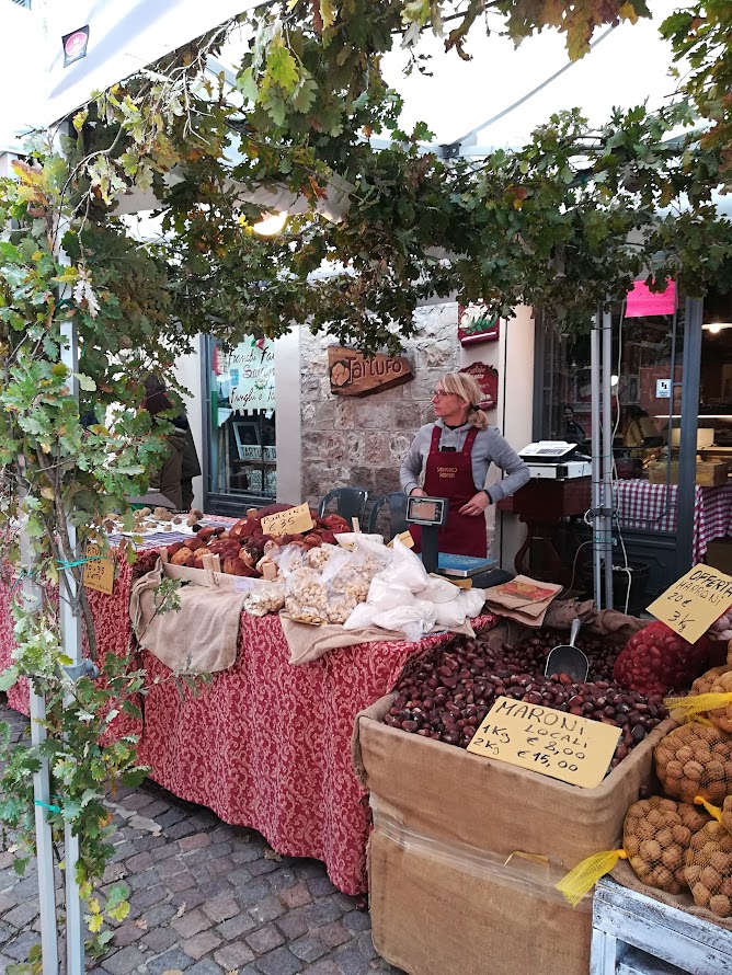 Food stalls and fresh produce at a covered Italian market hall