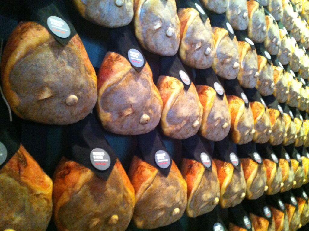 Parmaschinken hängen zum Reifen in einem Reifekeller in Langhirano bei Parma