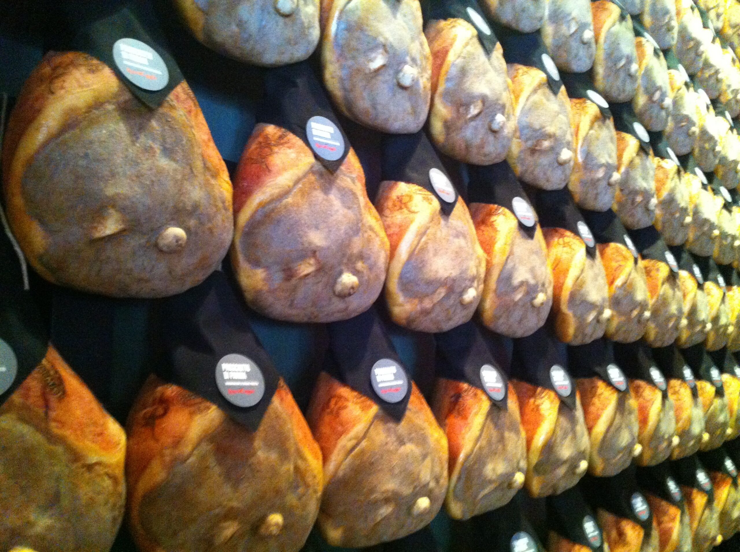 Parmaschinken hängen zum Reifen in einem Reifekeller in Langhirano bei Parma